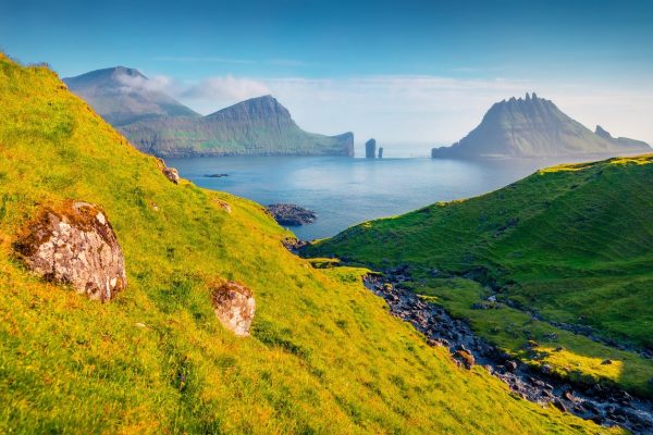Uitzicht op het water en de bergen op het eiland Tindholmur op de Faeröer elanden