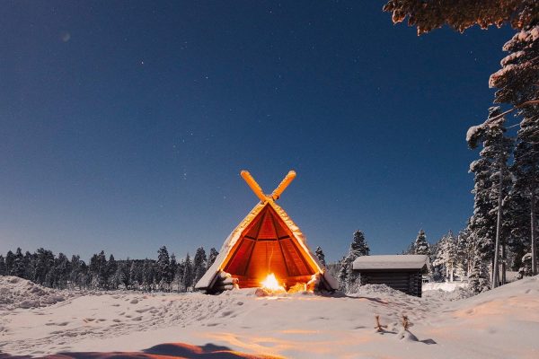 Wildernis hut met kampvuur in de nacht nabij Star Arctic hotel